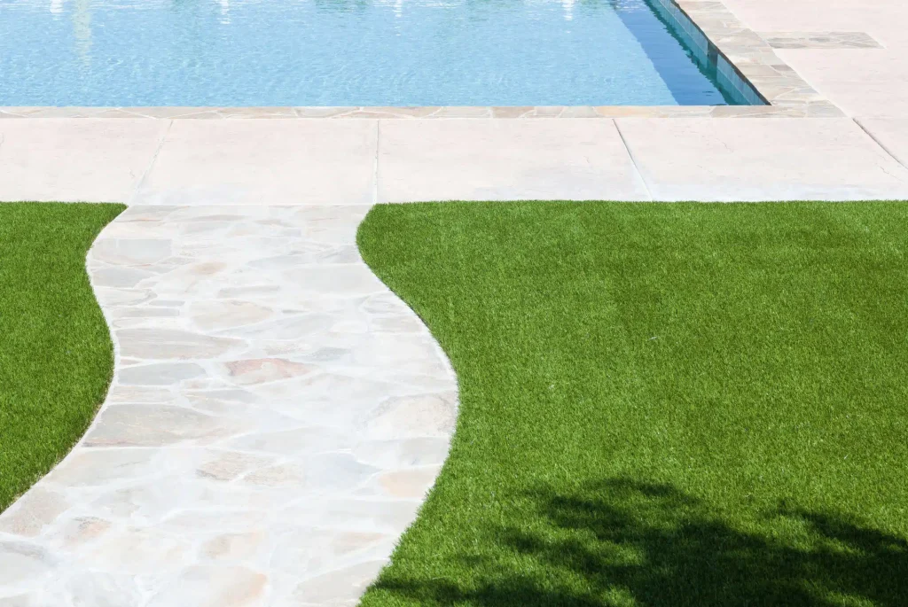 a pool with a grass lawn and a pool