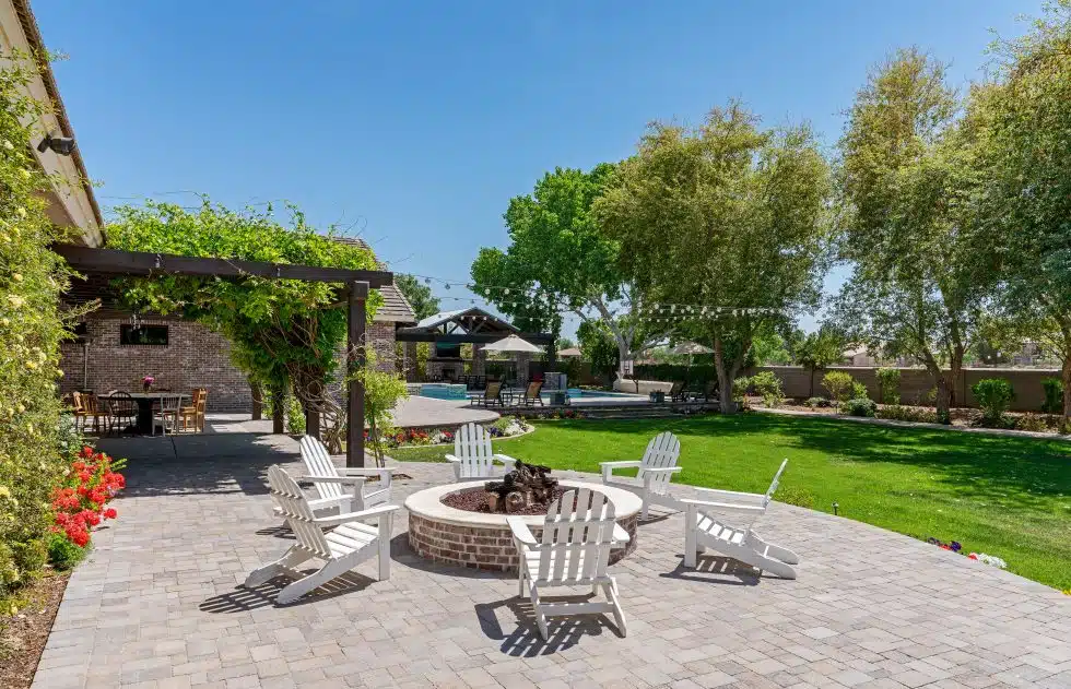 a patio with chairs around a fire pit