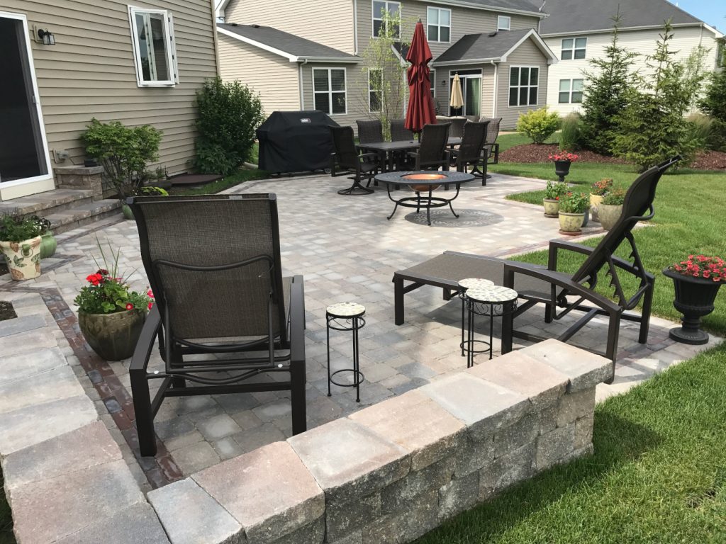 a patio with chairs and a fire pit