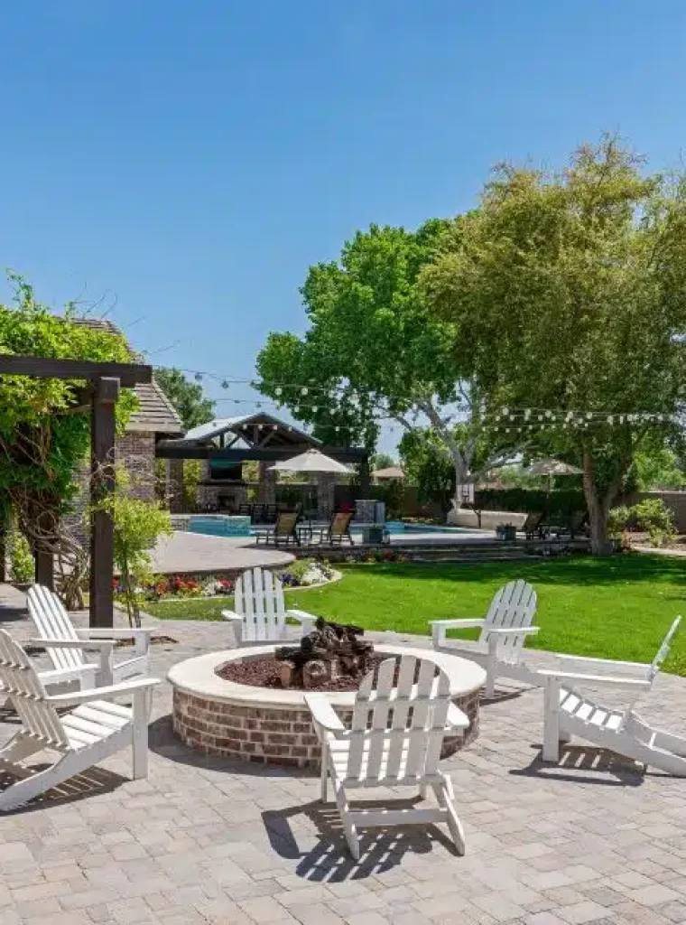 a patio with chairs around a fire pit